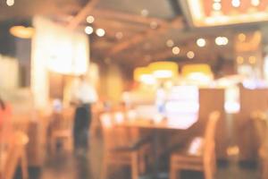 restaurantinnenraum mit kunden- und holztisch verwischen abstrakten hintergrund mit bokeh-licht foto