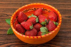 frische Erdbeere in einer Schüssel auf hölzernem Hintergrund foto