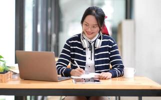 studenten lernen auf laptop drinnen - bildungskurs oder training, seminar, online-bildungskonzept, asiatin mit modernem laptop und kopfhörern, die zu hause lernen foto