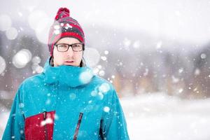 Porträt des jungen Mannes an einem verschneiten Wintertag foto