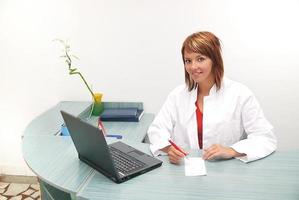 lächelnde Krankenschwester mit Laptop foto