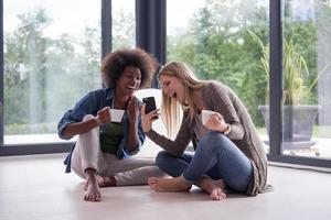 multiethnische frauen sitzen auf dem boden und trinken kaffee foto