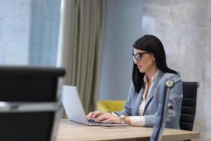 Geschäftsfrau, die einen Laptop im Startup-Büro verwendet foto