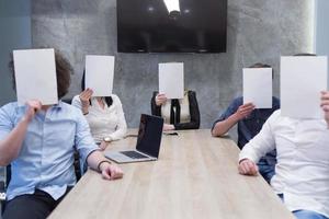 Startup-Business-Team mit einem weißen Papier über dem Gesicht foto