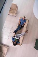 Junges multiethnisches Paar entspannt sich in der Draufsicht des Wohnzimmers foto
