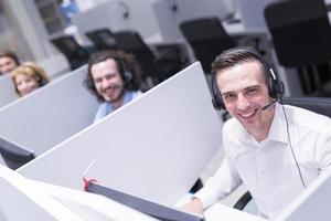 männlicher callcenter-betreiber, der seine arbeit erledigt foto