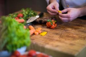 Nahaufnahme der Chefhände, die Rindersteak zubereiten foto