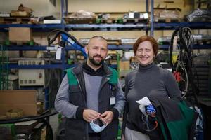 industriearbeiter mit gesichtsmasken, die vor dem corona-virus geschützt sind, diskutieren über die produktion in der fabrik. menschen, die während der covid-19-pandemie arbeiten. foto