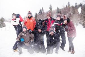 Gruppe junger Leute, die Schnee in die Luft werfen foto