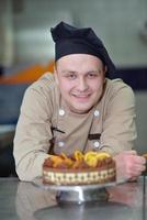 Koch bereitet Wüstenkuchen in der Küche zu foto