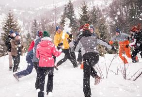 Gruppe junger Leute, die sich in der wunderschönen Winterlandschaft amüsieren foto