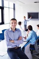 Geschäftsmann bei einem Treffen im Büro mit Kollegen im Hintergrund foto