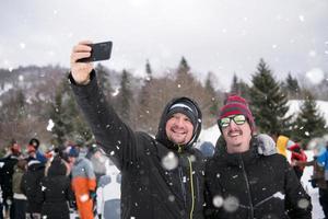 gruppe junger leute, die selfie in der schönen winterlandschaft machen foto