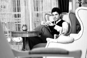 junger mann liest buch und entspannt sich im luxuriösen innenbereich foto