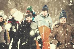 Gruppe junger Leute, die durch die wunderschöne Winterlandschaft spazieren foto