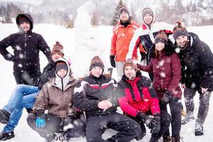 gruppenporträt von jungen leuten, die mit schneemann posieren foto