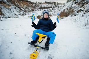 skandinavischer junge mit schwedenflagge in der schwedischen winterlandschaft. foto