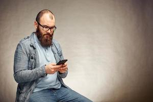 lebensstilgrübelnder mann mit bart und telefon, hintergrund, copyspace foto