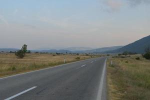 Straße durch die grüne Wiese foto