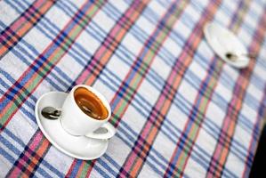 Tasse Kaffee auf einer bunten Tischdecke foto