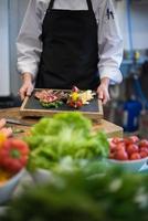 Köchin hält Rindersteakplatte foto