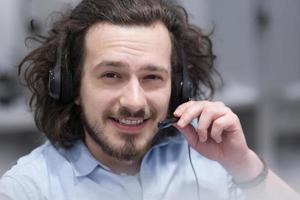 männlicher callcenter-betreiber, der seine arbeit erledigt foto