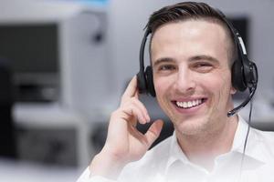 männlicher callcenter-betreiber, der seine arbeit erledigt foto