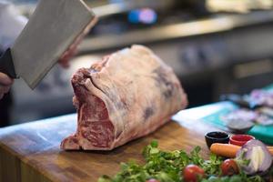 Koch schneidet ein großes Stück Rindfleisch foto