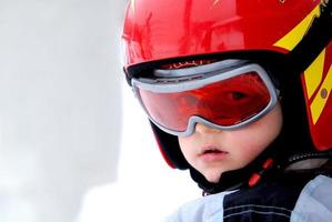 kleiner skifahrer mit helm und brille foto