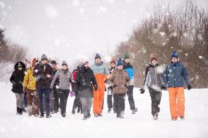 Gruppe junger Leute, die durch die wunderschöne Winterlandschaft spazieren foto