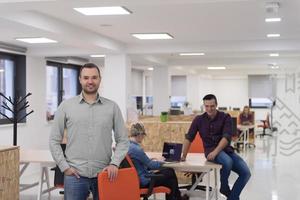 Startup-Unternehmen, Geschäftsmannporträt im modernen Büro, Team-Brainstorming im Hintergrund foto