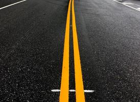 asphaltstraße mit gelben linien am abend des tages mit leeren autos, weicher und selektiver fokus. foto