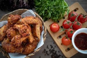 knusprig gebratenes Hähnchen im Körbchen mit Salat foto