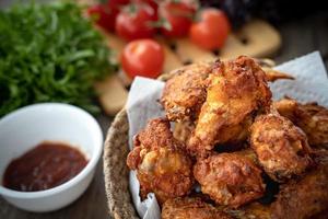 knusprig gebratenes Hähnchen im Körbchen mit Salat foto