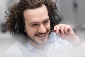 männlicher callcenter-betreiber, der seine arbeit erledigt foto