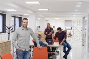 Startup-Unternehmen, Geschäftsmannporträt im modernen Büro, Team-Brainstorming im Hintergrund foto