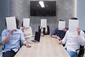 Startup-Business-Team mit einem weißen Papier über dem Gesicht foto