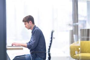 Geschäftsmann, der mit einem Laptop im Startup-Büro arbeitet foto