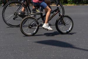 Junger Mann mit angepasstem Fahrrad zeigt seinen Stil, der an einem sonnigen Tag die Straße entlang fährt. foto