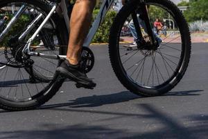 Junger Mann mit angepasstem Fahrrad zeigt seinen Stil, der an einem sonnigen Tag die Straße entlang fährt. foto