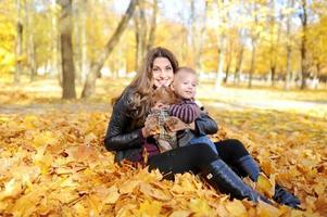 Mutter und Kind gehen im Herbstpark spazieren foto