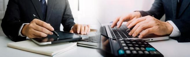 Geschäftsbuchhaltungskonzept, Geschäftsmann, der Taschenrechner mit Computerlaptop, Budget und Kreditpapier im Büro verwendet. foto