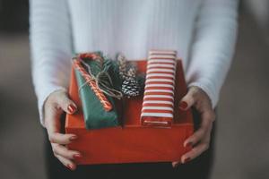 eine Frau, die Geschenke oder Geschenke für Feiertage gibt foto