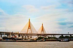 szene der bhumipol-brücke über den chaopraya-fluss in thailand und transport entlang des flusses. foto