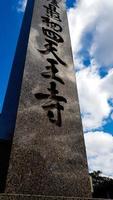 osaka, japan am 11. april 2019. ein obelisk-steinmonument steht stolz vor dem hintergrund weißer wolken an einem klaren himmel. foto