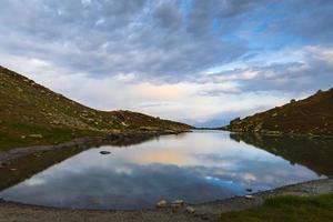 Luftschwenkansicht Udziro-Seepanorama im Herbst mit Zelten am See in felsigem Gelände im Freien foto