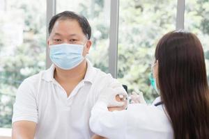 medizinisches personal wurde für covid-19 oder infektionskrankheiten für die asiatischen männlichen menschen geimpft, um die gesundheit vor krankheiten als gesundheitsschutz im krankenhaus zu schützen.