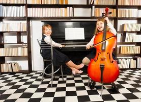 Mädchen spielen auf Violoncello und Klavier foto