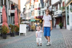 Bruder und seine kleine Schwester gehen im historischen Stadtzentrum spazieren foto
