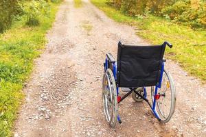 Leerer Rollstuhl, der auf der Straße steht und auf Patientendienste wartet. rollstuhl für menschen mit behinderung im freien geparkt. zugänglich für Menschen mit Behinderung. medizinisches konzept des gesundheitswesens. foto